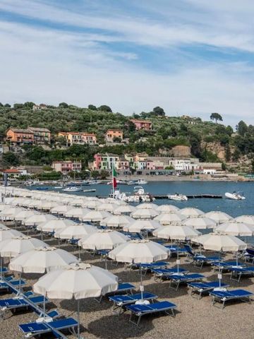 Strand mit zahlreichen Sonnenschirmen und bunten Häusern im Hintergrund