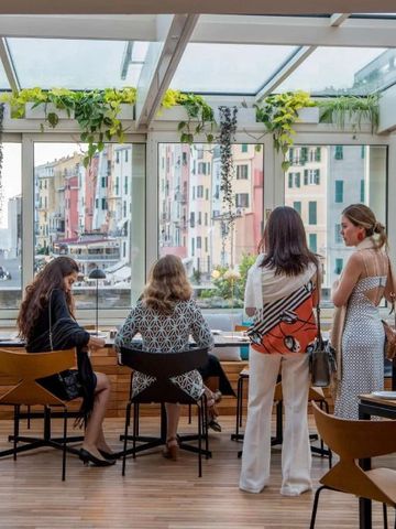 Restaurantgäste mit Blick auf bunte Gebäude durch große Fenster