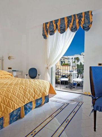 Doppelzimmer mit gelbem Dekor und Balkon mit Blick auf die Stadt.