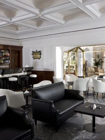 Elegante Hotelbar mit schwarzen Sofas und Marmorfliesen