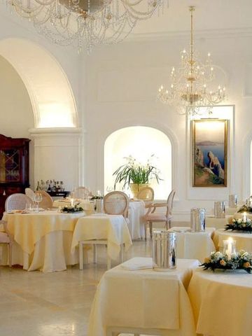 Stilvolles Restaurant mit weißen Bögen und edlen Tischdekorationen