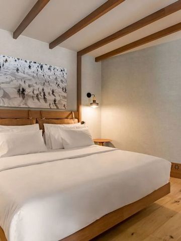 Gemütliches Hotelzimmer mit Holzboden und Kunstwerk an der Wand