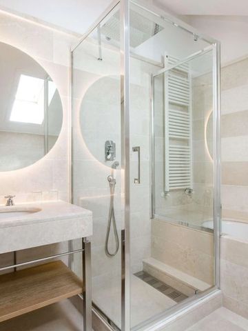 Modernes Badezimmer mit Glasdusche und runden Spiegeln