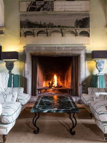 Gemütlicher Salon im Grand Hotel Son Net mit Kamin und stilvollen Sesseln.