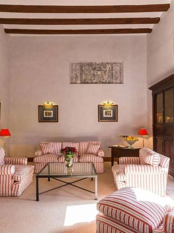 Charmant eingerichteter Salon mit gestreiften Sofas und Holzbalkendecke