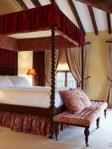 Luxuriöses Schlafzimmer mit Himmelbett und rustikalen Balkendecken