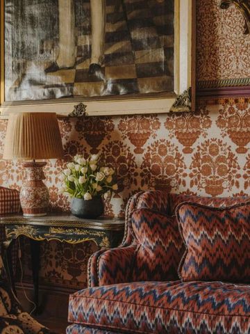 Opulentes Wohnzimmerdesign mit gemusterten Tapeten und antiken Möbeln