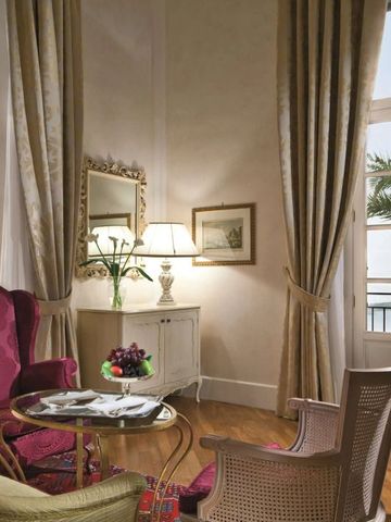 Helle Sitzecke mit zwei Stühlen und einem Tisch nahe großen Fenstern mit Meerblick