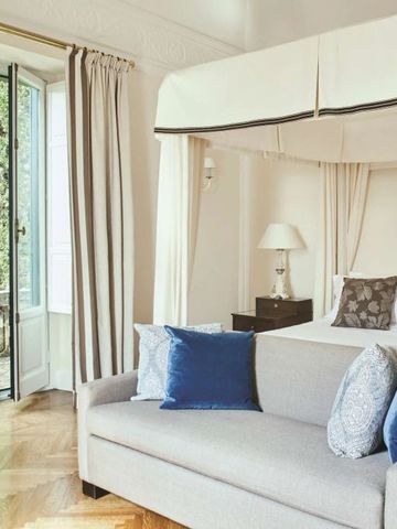 Geräumiges Schlafzimmer mit Himmelbett und Balkon mit Gartenblick