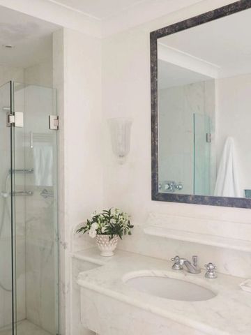 Luxuriöses Badezimmer mit Marmordekor und moderner Dusche