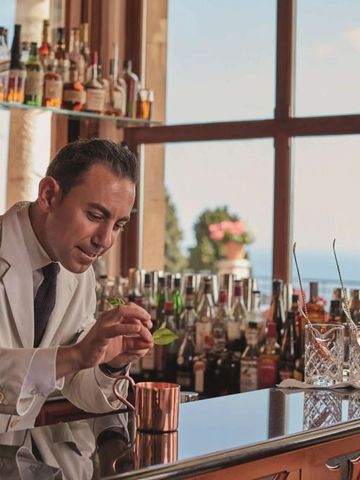 Stylische Bar mit Barkeeper und Blick auf das Meer