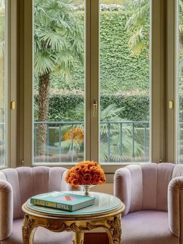 Elegantes Tischarrangement vor großen Fenstern mit Gartenblick.