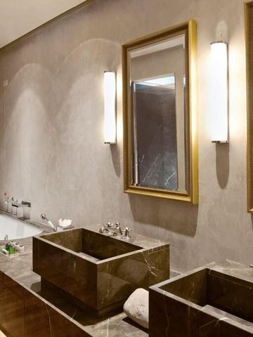 Luxuriöses Badezimmer mit Doppelwaschbecken und Marmorverkleidung.