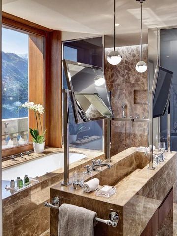 Elegantes Badezimmer mit Marmorwaschtisch und Blick auf den See