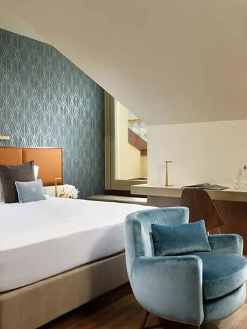 Stilvolles Zimmer mit modernem Design und gemütlicher Sitzecke unter Dachschräge.