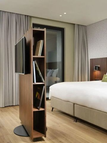 Geräumiges Zimmer mit Holzdetails, großem Bett und Lesebereich.