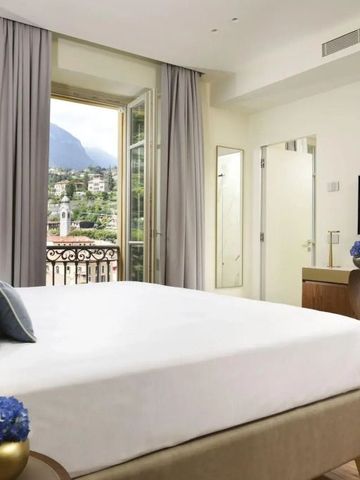 Luxuriöses Zimmer mit Balkon, modernem Design und vereinzelt blauen Dekor-Akzenten.