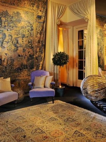 Luxuriöse Lounge mit historischen Wandteppichen und eleganten Sitzmöbeln