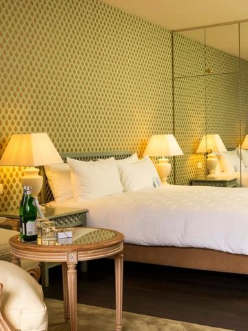 Komfortables Schlafzimmer mit eleganter Beleuchtung und Spiegelwand