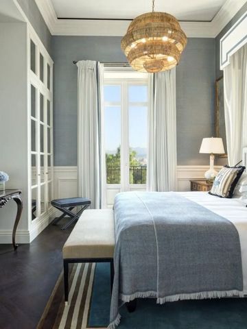 Helles Schlafzimmer mit großem Fenster, blauen und weißen Farbtönen