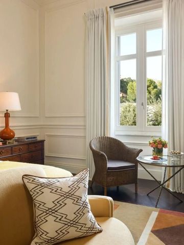 Helles Hotelzimmer mit Sitzbereich und Ausblick auf die Natur.