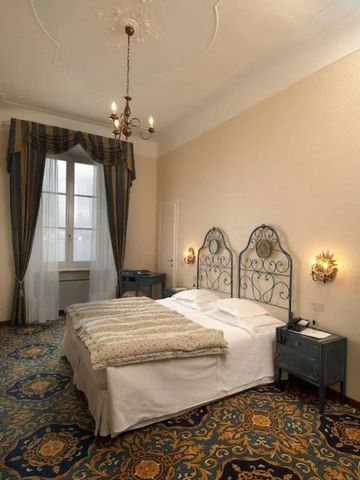 Klassisch eingerichtetes Hotelzimmer mit Doppelbett und stilvollen Vorhängen.