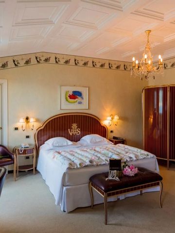 Luxuriöses Hotelzimmer mit Kronleuchter und kunstvoller Wanddekoration.