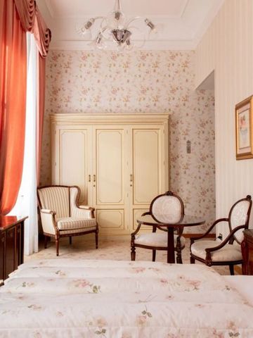 Geräumiges Schlafzimmer mit Sitzbereich und klassischer Dekoration