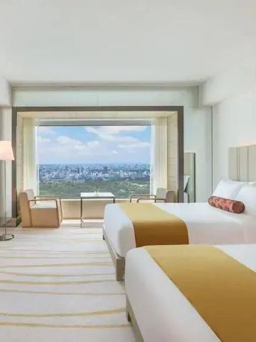 Geräumiges Hotelzimmer mit zwei Betten und Panoramablick auf die Stadt.