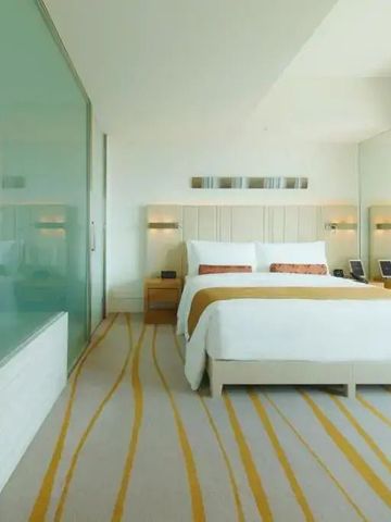 Helles Doppelzimmer mit Glaswand-Badezimmer und elegantem Design.