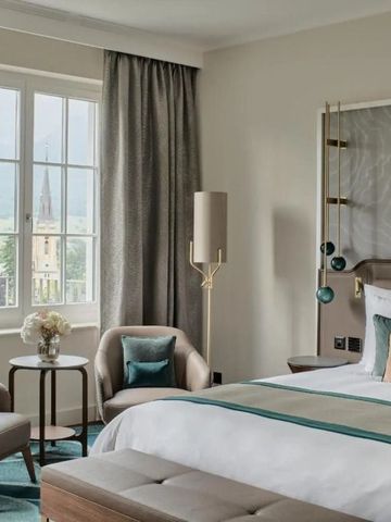 Elegantes Hotelzimmer mit großem Fenster und Blick auf eine Kirche.