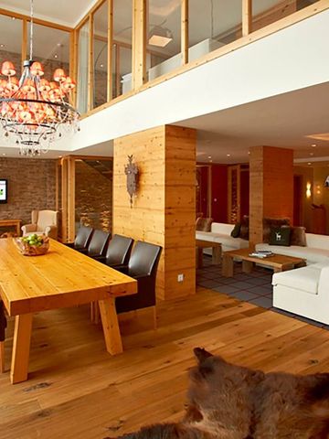 Luxuriöser Wohnbereich mit Holzmöbeln und Kronleuchter