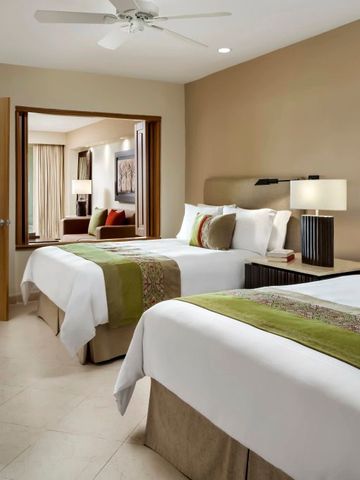 Komfortables Hotelzimmer mit zwei großen Betten und modernem Dekor.