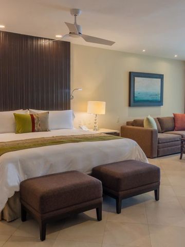 Luxuriöses Zimmer mit Kingsize-Bett und gemütlichem Sitzbereich.