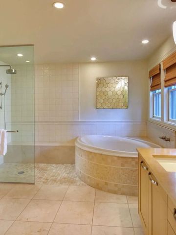 Luxuriöses Badezimmer mit Jacuzzi-Badewanne und moderner Glasdusche