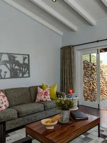 Gemütliches Wohnzimmer mit moderner Einrichtung und Zugang zur Naturstein-Terrasse