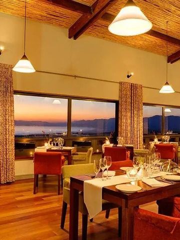 Elegantes Restaurant bei Sonnenuntergang mit Holzboden und Panoramafenstern