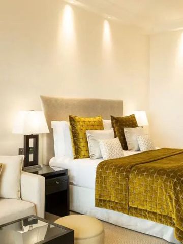 Luxuriöses Hotelzimmer mit goldener Bettdecke und stilvoller Dekoration