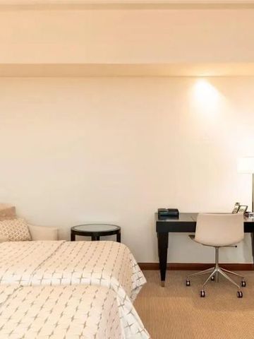 Hotelzimmer mit zwei Betten und einem Schreibtisch