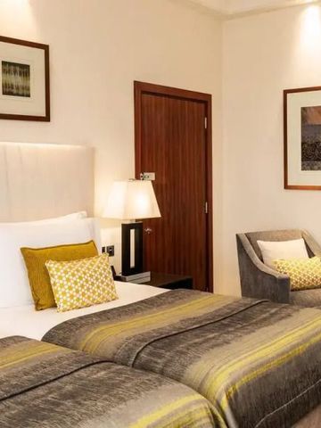 Elegantes Doppelzimmer mit Kunstwerken und gemütlicher Sitzecke