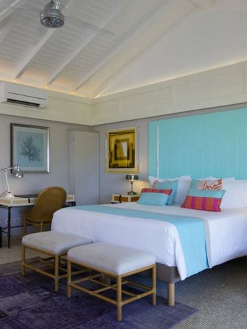 Geräumiges Zimmer mit Doppelbett, Schreibtisch und Kunstwerken an den Wänden