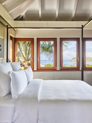 Zimmer mit mehreren Fenstern und atemberaubendem Meerblick im Hintergrund