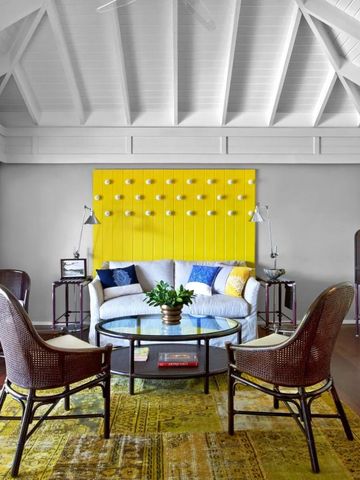 Wohnbereich mit gelber Akzentwand und stilvoller Einrichtung