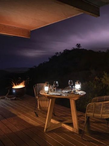 Terrasse mit Tisch und Stühlen bei Nacht mit Bergblick