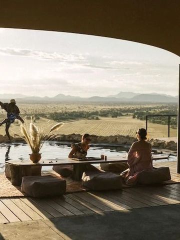 Lounge-Bereich am Pool mit Blick auf die weite Namib-Wüste