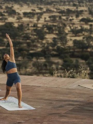 Frauen praktizieren Yoga mit Blick auf die Savannenlandschaft