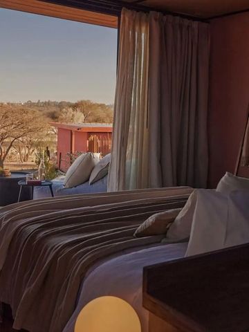 Gemütliches Schlafzimmer mit offenem Blick nach draußen und eleganten Vorhängen