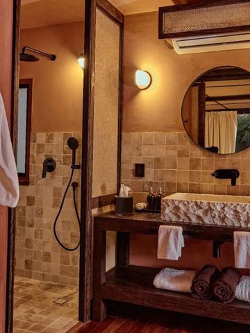 Modernes Badezimmer mit großer Dusche und Rundspiegel