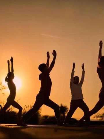 Menschen bei Yoga-Posen im Sonnenuntergang