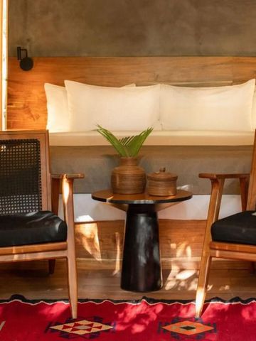 Zimmer mit Holzdetails, gemütlichen Sesseln und bunter Dekoration